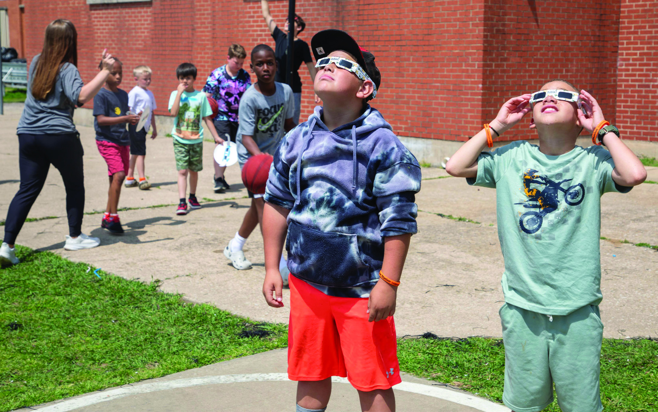 Boys &amp; Girls Club of Durant gathered on the playground to view the eclipse on Monday and Matthew Brandenburger and Markis Hamilton are shown gazing skyward.