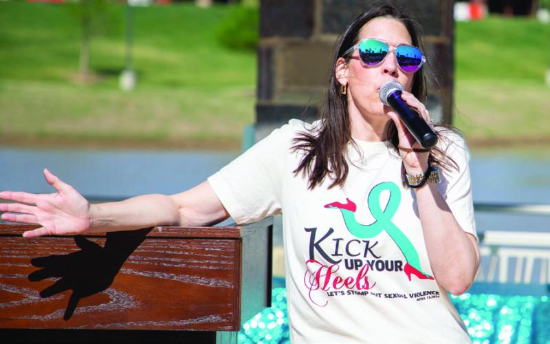 Anna Marcy, director of the Family Violence Prevention Program at the Choctaw Nation, speaks during the Kick up Your Heels walk at the Choctaw Amphitheater.