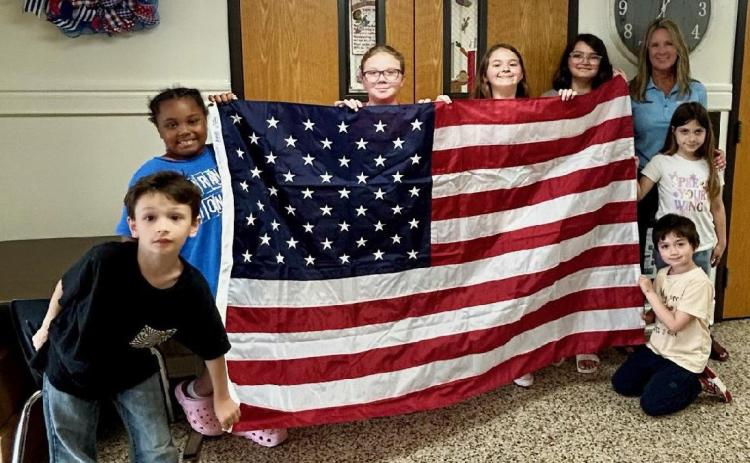 Washington Irving students and staff would like to say a big thank you to WoodmenLife for donating an American flag and an Oklahoma flag to the school. Shown with WI students is WoodmenLife representative Sherri Elmore. Photo provided | WI
