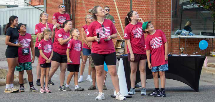 Taylor Shipp and others watch as balloons are released in memory of Bryan County Sheriff’s Deputy Jarid Taylor before the start of the memorial run. Shipp is the race director and Taylor’s cousin. Matt Swearengin | Durant Democrat