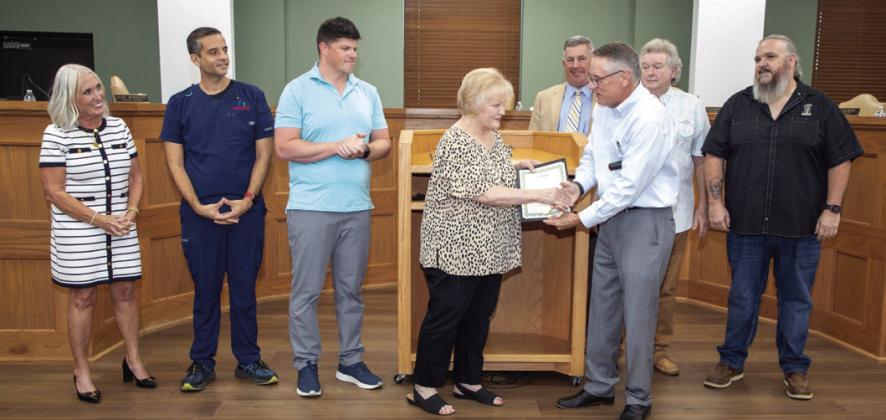 Durant Mayor Martin Tucker, in a recent city council meeting, presents Sue Stanfield, founding director of Hands of Hope, with a proclamation declaring Aug. 11 Sue Stanfield Day. Also shown from left, City Manager Pam Polk, Vice Mayor Mike Simulescu, Council Member Clint Morrison, Assistant City Manager/attorney Doug Elliott and city council members Danny Sherrer and Humphrey Miller. Matt Swearengin | Durant Democrat