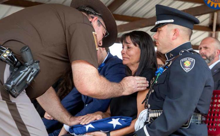Teresa Christian, widow of Bryan County Sheriff Johnny Christian, is presented the flag from Christian’s casket during the service at Highland Cemetery before Christian was laid to rest. Also shown is Kimo Puana, son to the Christians. Matt Swearengin | Durant Democrat