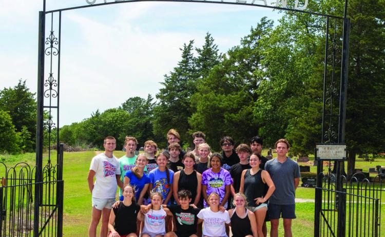 The Silo High School track and field team poses in front of the entrance to Silo Restland Cemetery. Matt Swearengin | Durant Democrat