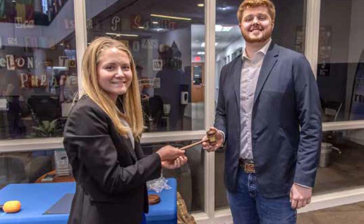 Outgoing Southeastern Oklahoma State University Student Government Association President Sarah Coblentz hands the SGA President’s gavel to incoming President Dylan Klaassen Dan Hoke | SE