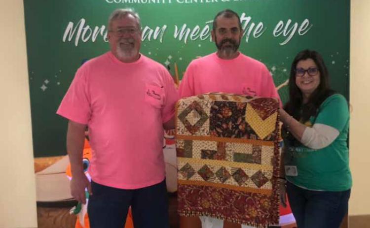Mike Baird won a quilt during the Friends of the Library Holiday Craft Show. From left, Lowell Smith, Mike Baird and Angie Mullen. Baird donated the quilt back to the Friends of the Library. Photo provided