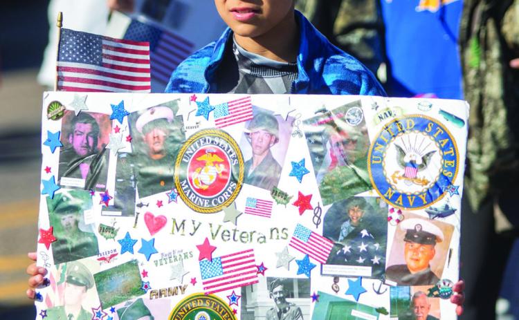 Eric Peterson, a student at Rock Creek, holds a sign during the Veterans Day parade in downtown Durant. Matt Swearengin | Durant Democrat