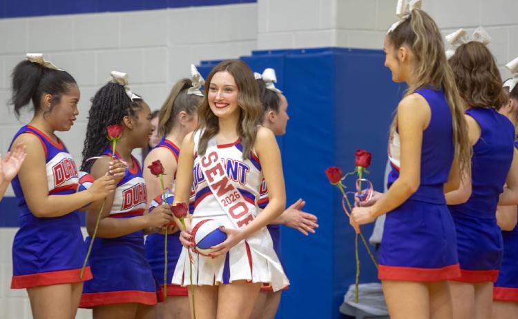 Durant High School senior cheerleader Jolie McClure is congratulated during the recent senior night in between the basketball games.