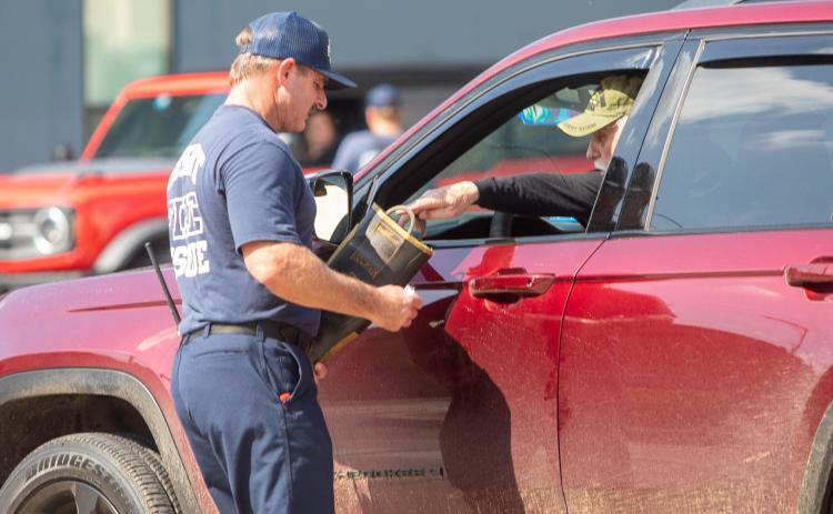 Durant Fire Department Battalion Chief Jeff Orlando accepts a donation from a citizen during last week’s Fill the Boot campaign by the International Association of Fire Fighters to raise funds for the Muscular Dystrophy Association. Matt Swearengin | Durant Democrat