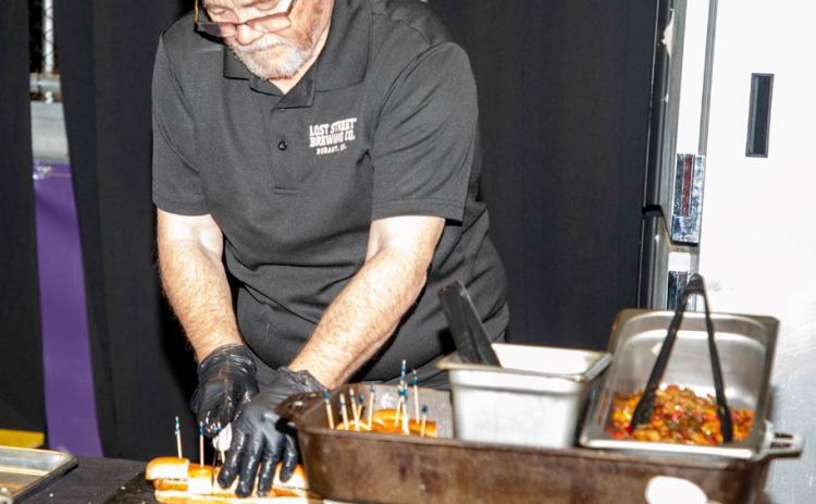 Scott Dewald of Lost Street Brewing Co. prepares bratwurst samples during the annual Taste of Durant at Choctaw Event Center.