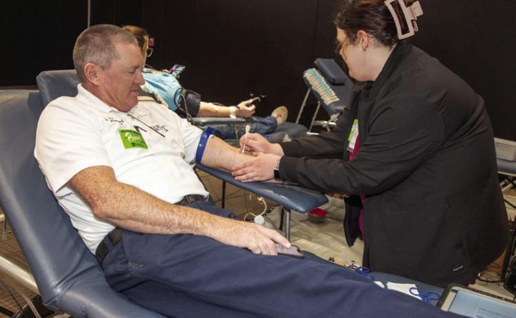Kaitlyn Boyd, phlebotomist with Our Blood Institute, draws blood from Durant Fire Chief Je Langford during the Boots and Badges blood drive at the Donald W. Reynolds Community Center &amp; Library.