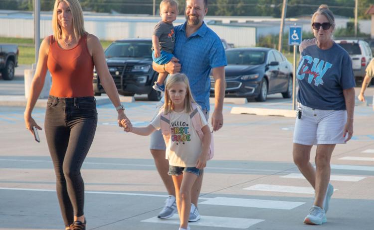 Parents bring their child to George Washington Elementary school for the first day of classes.