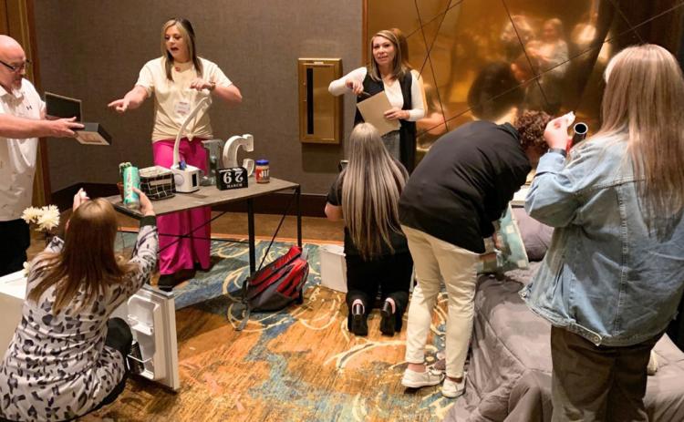 Coordinators Kelsea Johnson and Brittany Whitworth count items the participant team finds that could hold drugs or drug paraphernalia in the mock bedroom.