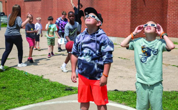 Boys &amp; Girls Club of Durant gathered on the playground to view the eclipse on Monday and Matthew Brandenburger and Markis Hamilton are shown gazing skyward.
