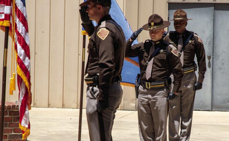 Members of the Oklahoma Highway Patrol Honor Guard salute after posting the colors during a memorial service Sunday afternoon at Boland Park in Caddo to remember the three troopers killed in the line of duty on May 26, 1978, with McAlester Prison escapees. Matt Swearengin | Durant Democrat