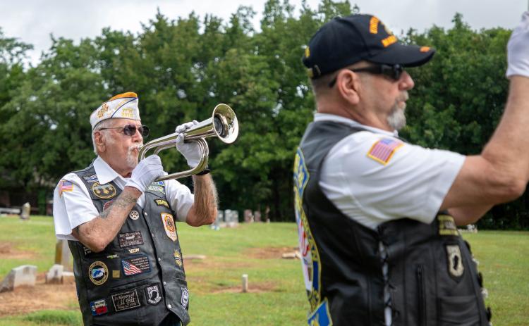 Don Papin, past commander of VFW Post 3916, plays Taps while Ron Winters, DAV commander, raises the flag during a Memorial Day service at Silo Restland Cemetery. Matt Swearengin | Durant Democrat