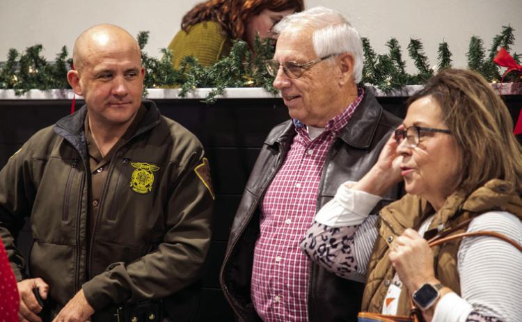 Oklahoma Highway Patrol Lt. Joe Nichols, left, and retired OHP communications o_cer Tom Garner and his wife Sandra are shown at the OHP Christmas party. Matt Swearengin | Durant Democrat