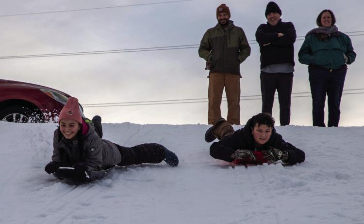 Matt Swearengin | Durant Democrat Hannah Williams and Hayes Williams slide down the hill at Carl Albert Park last week after the sleet storm left the city caked with about four inches of ice.