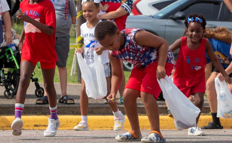 Children pick up candy during the Bokchito Homecoming Parade.