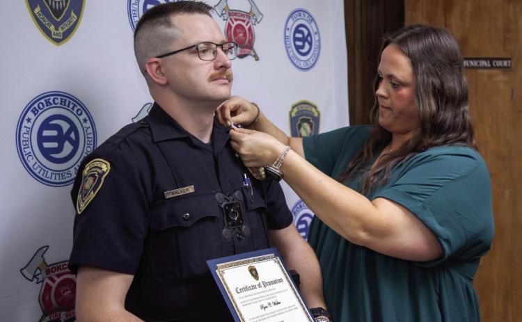 Kelsey Walker, Bokchito town clerk/court administrator, pins a sergeant insignia on Ryan Walker of the Bokchito Police Department. Walker was promoted last week and a ceremony was held at city hall. Matt Swearengin | Durant Democrat