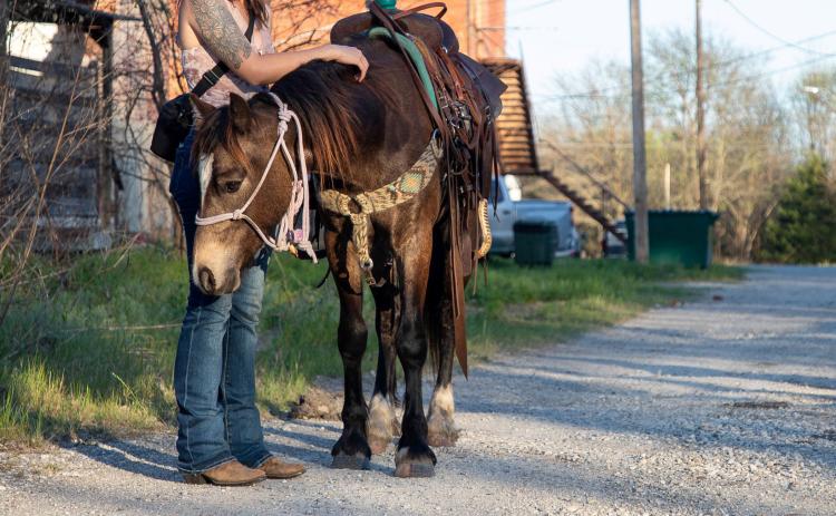 Justine Jackson walked her horse down the alley behind Buffalo Street in downtown Caddo recently. She owns Riding Free Equine. Matt Swearengin | Durant Democrat