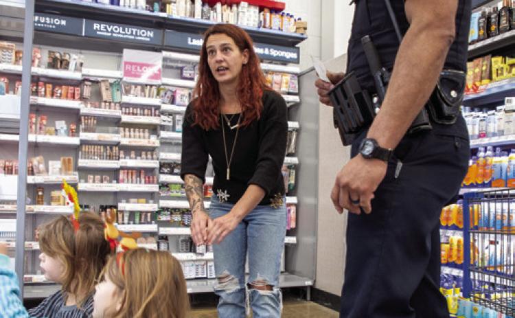 Matt Swearengin | Durant Democrat Durant Police O_cer Clayton Yarbrough assists Nichelle Nelson and her two children, Sara, 6, and Micah, 5, during Shop with a Cop Dec. 23 at Walmart. The event is by the Durant Police Reserves with assistance from o_cers from dierent departments.