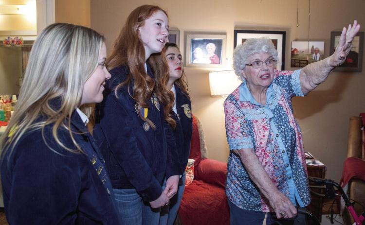 Featherstone Assisted Living of Durant resident Pat Praytor points out family photos to Durant FFA students Bailee Varner, Lydia Bullard and Bethany Randolph, who visited the center Feb. 13 to pass out Valentine’s Day gift bags. Matt Swearengin | Durant Democrat