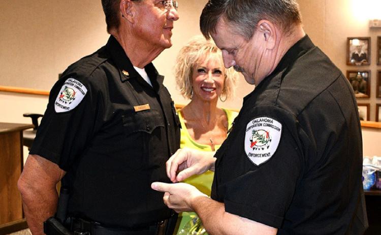 Chuck Carroll of Bryan County was promoted to major in the Oklahoma Corporation Commission’s (OCC) Transportation Enforcement Division. Transportation Chief Scott Baze pinned the oak leaves on Carroll’s shirt collar and also shown is Carroll’s wife, Angie. Photo provided