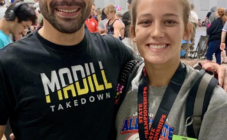 Gage Vaughn after winning her gold medal and qualifying for Junior Nationals stands with Coach Peter Hammer. Photo provided | Madill Wresting Club