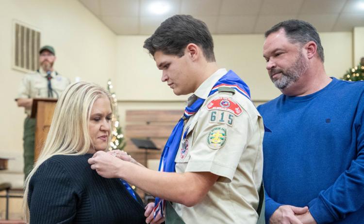 Braxton Manous earned Eagle Scout and he gives his mother Corbi Manous a pin during the ceremony. Also shown is Braxton’s father Jason Manous.