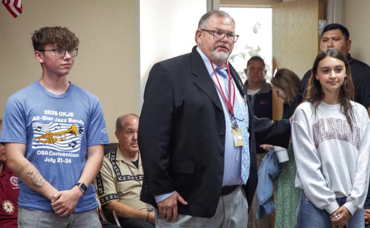Pride of Durant head band director Chris Gregg spoke to the Durant Board of Education about the recent accomplishments of the band. On the left is Caden Smith, percussion section leader, and on the right is Emma White, one of the Sparkler leaders. Matt Swearengin | Durant Democrat