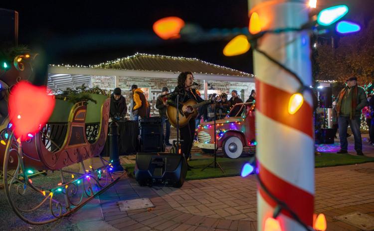 ABOVE: Jordan Rainer, an award-winning singer-songwriter from Atoka, performed at the Market Square Christmas tree lighting ceremony. Matt Swearengin | Durant Democrat RIGHT: The City of Durant Christmas at Market Square was lit following the Christmas parade Dec. 2.