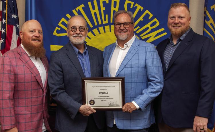 Dr. David Whitlock presents J. Scott Crain, Chase Crain (far left), and Drew Crain (far right) with a plaque honoring their 2026 Oklahoma State Regents for Higher Education’s Regents Business Partnership Excellence Award.