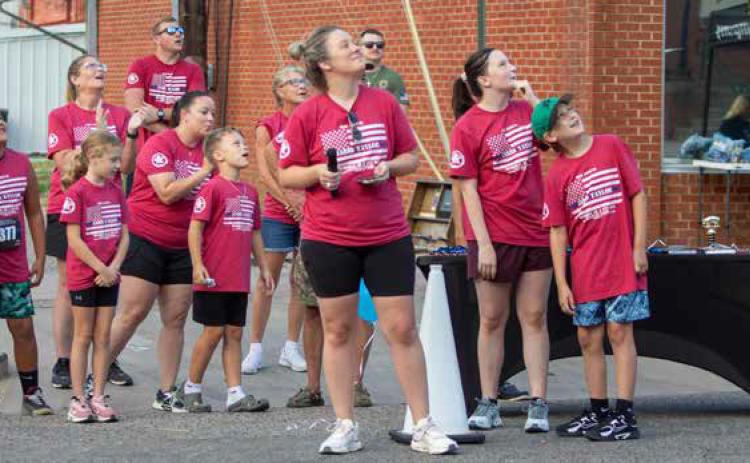Taylor Shipp and others watch as balloons are released in memory of Bryan County Sheriff’s Deputy Jarid Taylor before the start of the memorial run. Shipp is the race director and Taylor’s cousin. Matt Swearengin | Durant Democrat