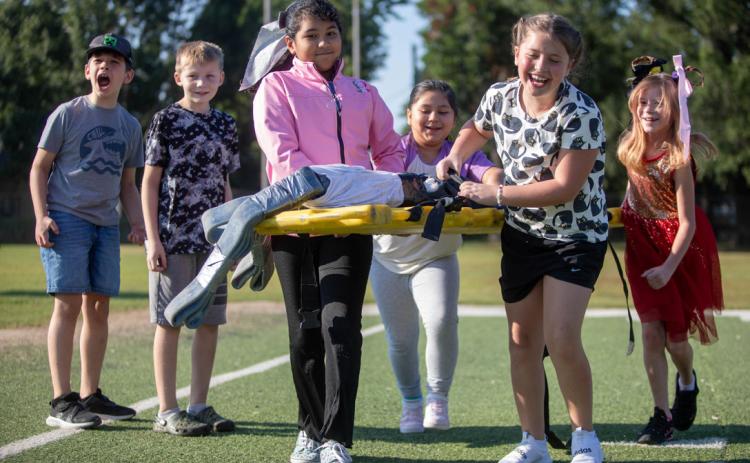 Washington Irving third graders carry a Durant Fire Department stretcher. Firefighters visited all of the elementary schools last week to give children a hands-on experience with firefighter equipment. Matt Swearengin | Durant Democrat