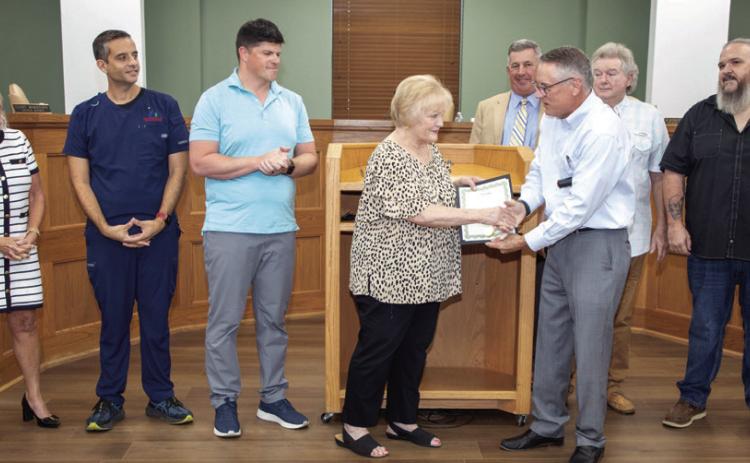 Durant Mayor Martin Tucker, in a recent city council meeting, presents Sue Stanfield, founding director of Hands of Hope, with a proclamation declaring Aug. 11 Sue Stanfield Day. Also shown from left, City Manager Pam Polk, Vice Mayor Mike Simulescu, Council Member Clint Morrison, Assistant City Manager/attorney Doug Elliott and city council members Danny Sherrer and Humphrey Miller. Matt Swearengin | Durant Democrat