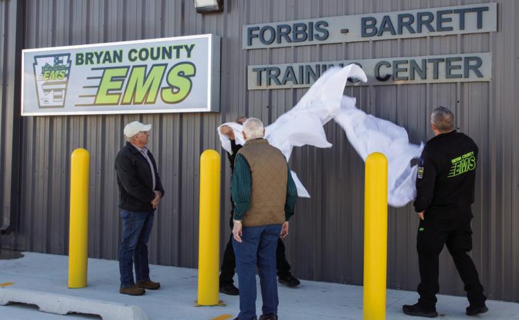 The sign for the new Bryan County EMS Forbis-Barrett Training Center is unveiled during a ceremony last week. Matt Swearengin | Durant Democrat