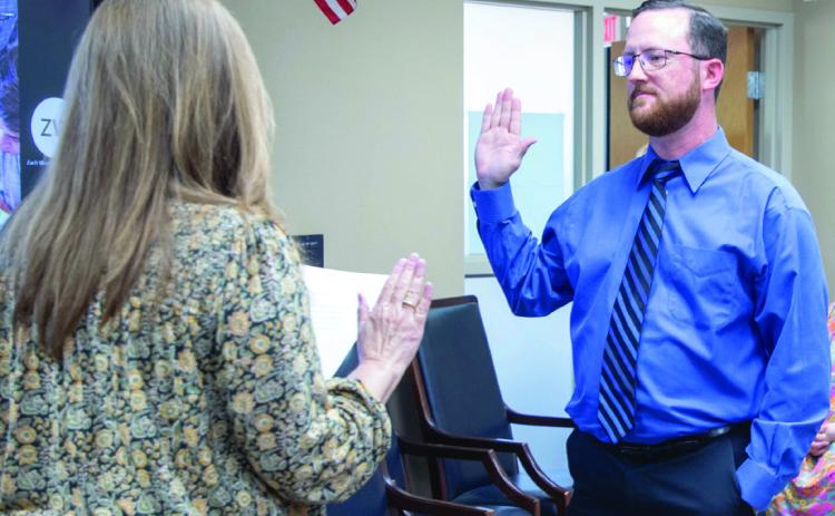Casey Powers, a new board member for the Durant Board of Education, is sworn in Monday by LeAnna Cha_n, clerk of the board for Durant Schools. Matt Swearengin | Durant Democrat