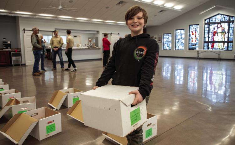 Jace Cater, 12, helped during the recent Bryan County United Way Christmas boxes for veterans event at the St. William Catholic Church Parish Hall. Matt Swearengin | Durant Democrat