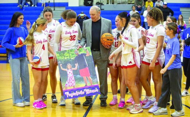 ABOVE: The Durant Lady Lions basketball team won a home game Saturday over Pryor 43-41. Their head coach, Will Robinson and daughter Clara, passed away during a Christmas Eve car accident. Will’s father, Tony Robinson, is leading the team through the season and he was presented a basketball signed by team members. The win secured a home Class 5A regional for the first for the team time since 2008. See game story on sports, page 10.