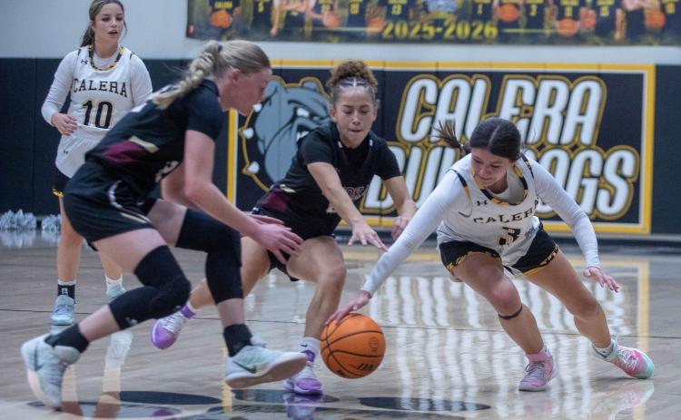 Matt Swearengin | Durant Democrat Calera Lady Bulldog Jadelyn Pierce and Atoka Lady Wampus Cats lunge for the ball during the Dec. 5 homecoming game at Calera. Also shown is Lady Bulldog Harlie Gardner.