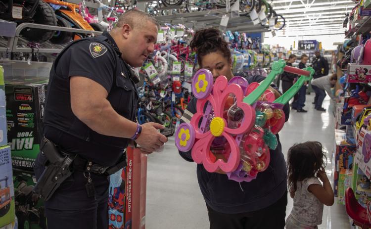 Durant Police Officer Josh Mullins helps shoppers during the Durant Police Department’s Shop with a Cop event Dec. 19 at Walmart. Matt Swearengin | Durant Democrat
