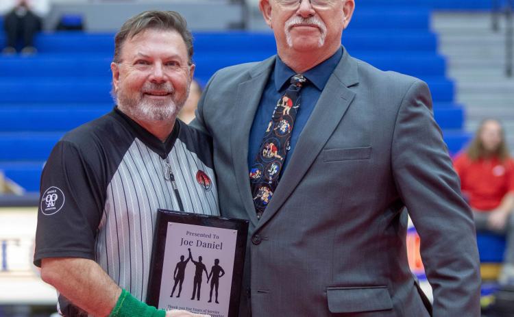 Joe Daniel was presented a plaque at a recent Durant High School wrestling dual thanking him for 41 years of service as a wrestling referee and supporter. Durant wrestling head coach Jim Taylor presented the plaque. Matt Swearengin | Durant Democrat