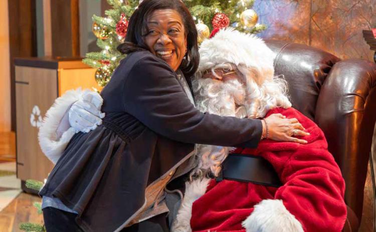 ABOVE: Lawanda Brown reacts while embracing Santa Claus at the Choctaw Christmas last Saturday at the Choctaw Cultural Center. The one-day event had treats and activities for all ages to enjoy and learn. Complimentary photos with Santa were taken.