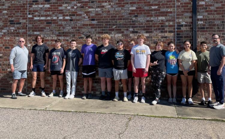 Durant wrestling team and coaches helped unload a trailer full of quilting fabric from the estate of Dr. Rebecca Davis. The fabric, along with quilting books and magazines, will be sold at a later date with all the proceeds going to J127. Photo provided