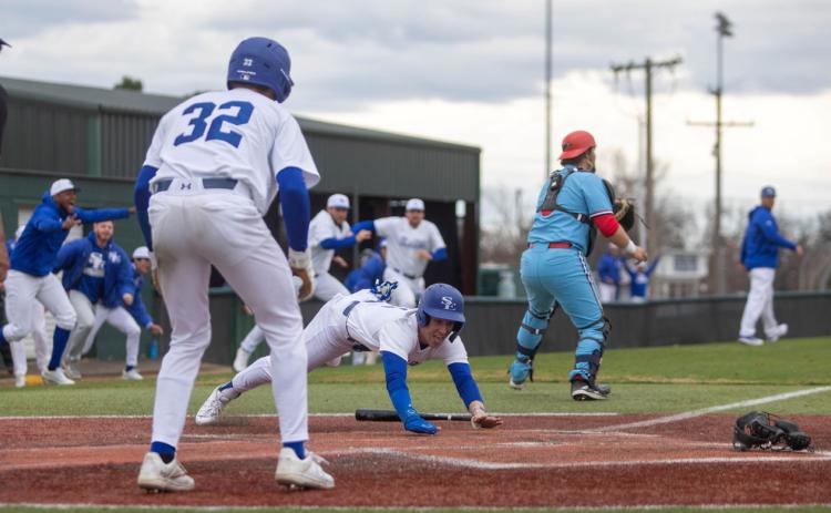 Southeastern baseball player John David Muse leaps onto home plate during the end of a game Saturday with Newman University that the Savage Storm won. Matt Swearengin | Durant Democrat