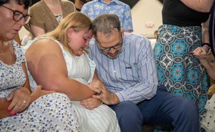 Durant Church of Christ Family minister Logan Cates, right, prays with Dylan Harendt after she came forward on a recent Sunday. Matt Swearengin | For The Christian Chronicle