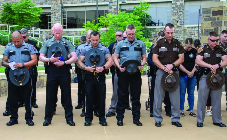 Law enforcement o_cers bow their heads in prayer during the annual Law Enforcement Memorial Tribute May 16 at the Choctaw Nation Headquarters Amphitheater. Matt Swearengin | Durant Democrat