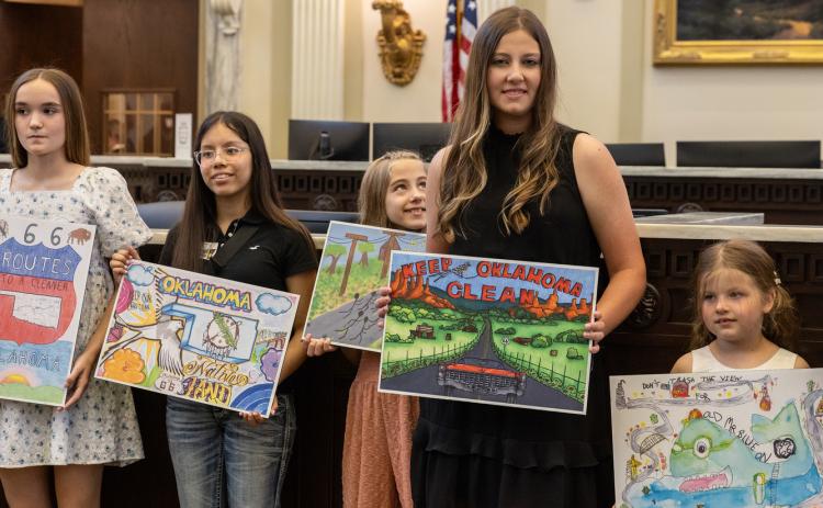 Rep. Cody Maynard is shown with Andrea Ramos, second from left, and Rilyn Teafatiller, second from right, display their winning artwork in the ODOT Trash Poster Contest on the House floor. Photo provided