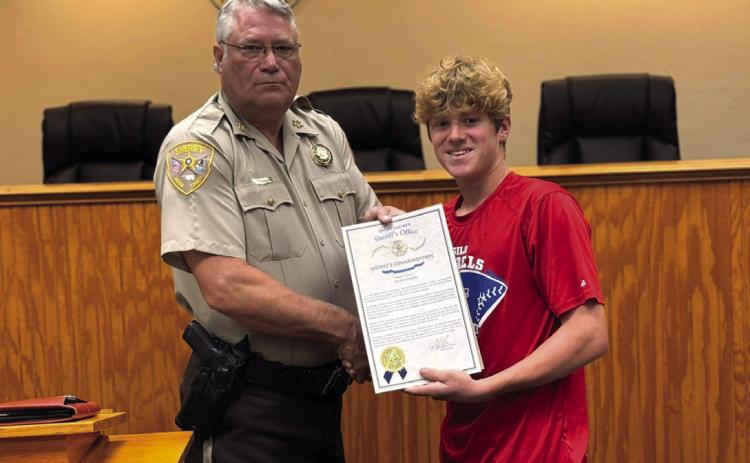 Bryan County Sheri_ Johnny Christian presents Colton Parker a Sheri_’s Commendation and Parker was also named an honorary sheri_’s deputy for his bravery when encountering a burglar. Photo provided
