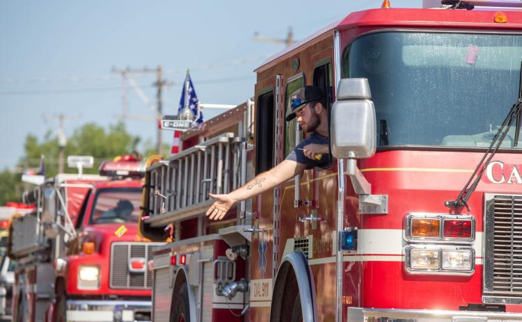 A Caddo firefighter throws candy during the Caddo Roundup Club Rodeo Parade Saturday morning on Buffalo Street. Matt Swearengin | Durant Democrat